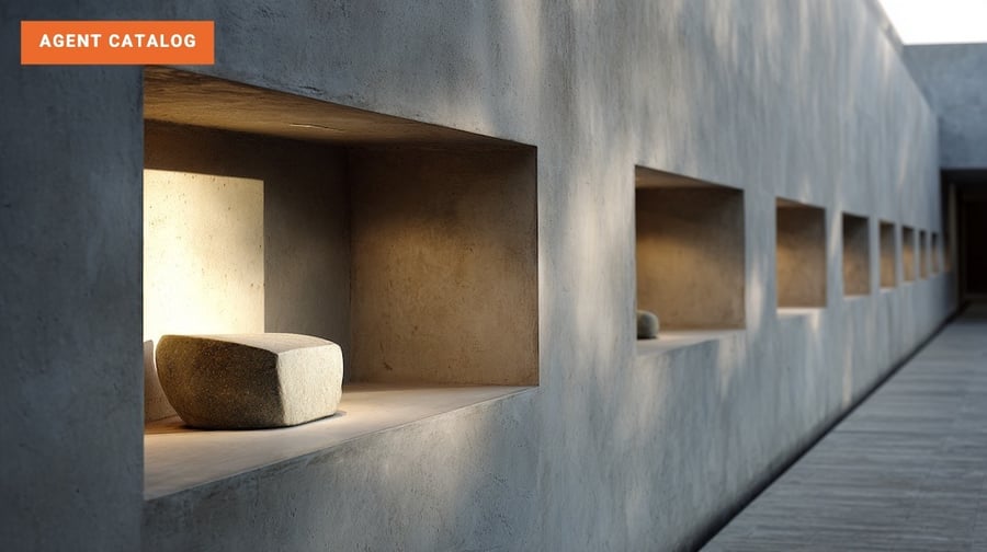 A long gallery of pale concrete alcoves in soft daylight, each holding a stone block except one that stands empty.
